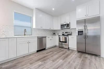 a kitchen with white cabinets and stainless steel appliances at Miami Modern Oasis Retreat - Close to Airport in Miami
