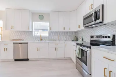 a kitchen with white cabinets and stainless steel appliances at Executive Retreat Unit 1 - Fort Lauderdale in Fort Lauderdale