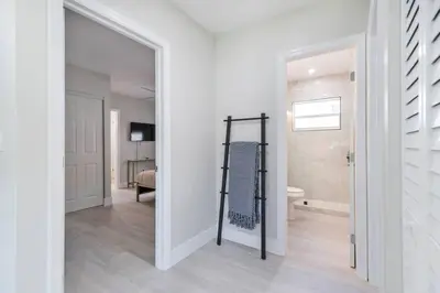 a white room with a mirror and a bathroom at Cozy Victoria Park Retreat Unit 3 - Las Olas Beach in Fort Lauderdale