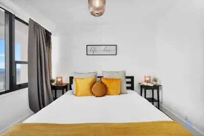 a bedroom with a large white bed with yellow pillows at 2BR Pool Ocean View in Miami Beach