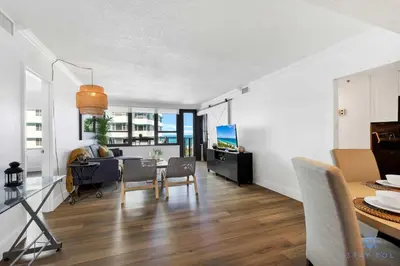 a living room with a table and a couch and a television at 2BR Pool Ocean View in Miami Beach