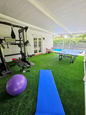 a gym with a purple ping pong table and a ping pong ball at Brickell Enclave Sunny Retreat with pool in Miami