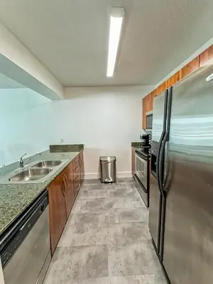 a kitchen with a stainless steel refrigerator and a sink at Elegant Centric Vibrant Pool Jacuzzi Free Parking in Miami