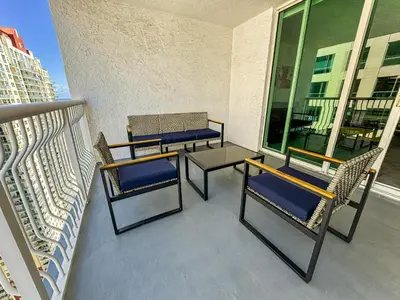 a balcony with chairs and tables on a building at Elegant Centric Vibrant Pool Jacuzzi Free Parking in Miami