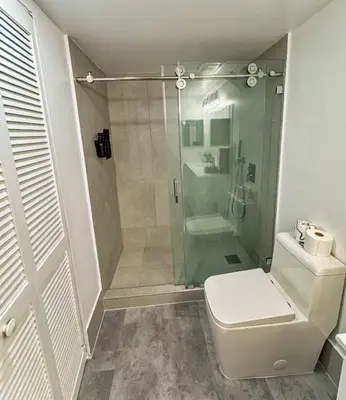 a bathroom with a shower with a toilet and a sink at Elegant Centric Vibrant Pool Jacuzzi Free Parking in Miami