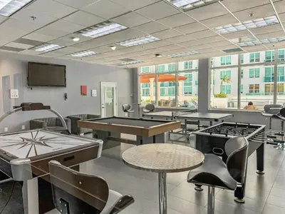 a room with tables and ping pong tables at Elegant Centric Vibrant Pool Jacuzzi Free Parking in Miami