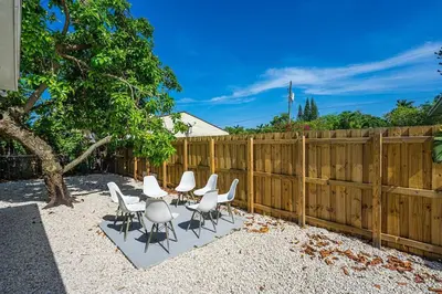 a group of white chairs and a fence at Modern Oasis Unit 2 - Close to Beach, Brickell & Airport in Miami