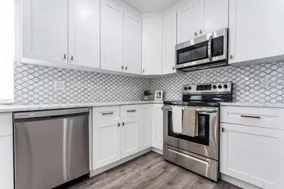 a kitchen with white cabinets and stainless steel appliances at Modern Miami Unit 1 - Close to South Beach & Airport in Miami