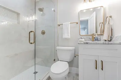 a white bathroom with a toilet and a shower at Modern Miami Unit 1 - Close to South Beach & Airport in Miami