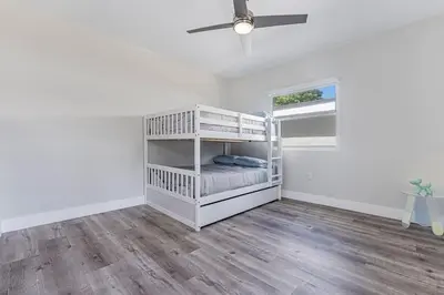 a white bedroom with a bunk bed and a ceiling fan at Modern Miami Unit 1 - Close to South Beach & Airport in Miami