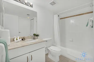 a white bathroom with a toilet and a sink at Beautiful 1BR Apartment with Amenities in Miami