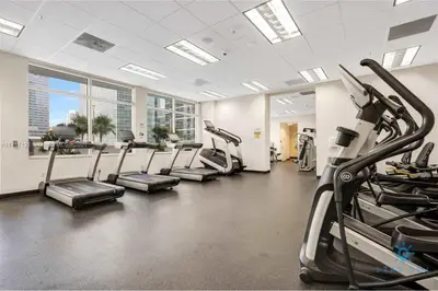 a gym with treadmills and ellipticals in a building at Beautiful 1BR Apartment with Amenities in Miami