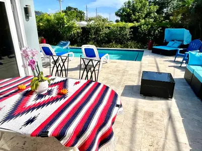 a patio with a table and chairs and a pool at POOLSIDE MANOR - Men Only Clothing-Optional in Fort Lauderdale