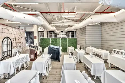 a dining room with white tables and white chairs at Grand Deluxe Two Bedroom Suite with Balcony Water Views, Corner in Miami Beach