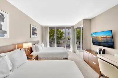 a hotel room with two beds and a tv at Grand Deluxe Two Bedroom Suite with Balcony Water Views, Corner in Miami Beach