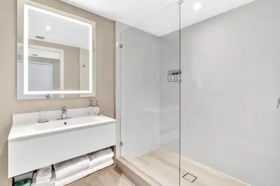 a bathroom with a sink and a glass shower at Grand Deluxe Two Bedroom Suite with Balcony Water Views, Corner in Miami Beach