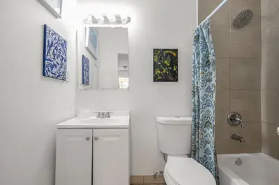 a bathroom with a toilet and a sink and a mirror at Private Rooms at Miami, Buena Vista with Parking in Miami