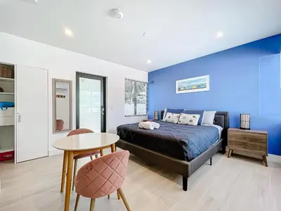 a bedroom with a blue wall and a bed and a table at Los Patios Home Suites in Miami Beach
