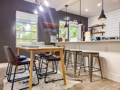 a kitchen with a wooden table and stools at Melrose Villa in Miami