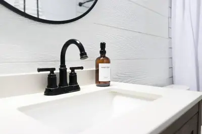 a bathroom sink with a bottle of soap on it at Melrose Villa in Miami