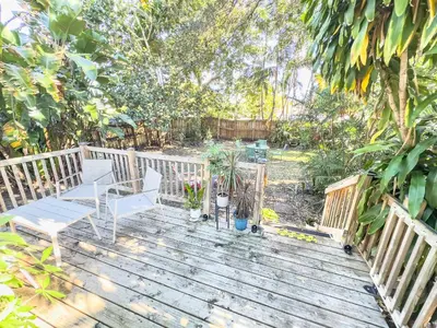 a wooden deck with two chairs and a table at Melrose Villa in Miami