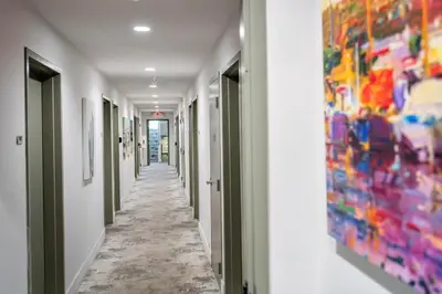 an aisle in a hospital hallway with art on the walls at 7130 Costa Boutique in Miami Beach