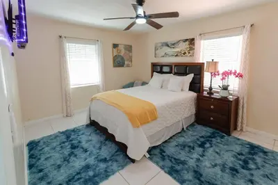 a bedroom with a bed with blue rugs and a ceiling fan at CasaBay 4 Bed 2 Bath House Ultimate Backyard Fun in Cutler Bay