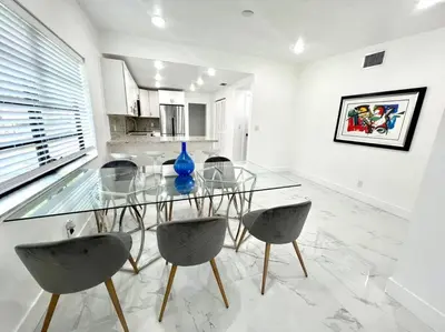 a dining room with a glass table and chairs at Miami Oasis Near Beach in North Miami