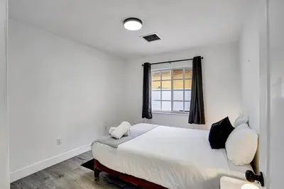 a white bedroom with a bed and a window at 8BR-4BA Spacious House, Sleeps 20, Pool, Fenced Yd in Miami
