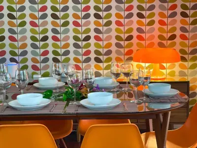 a table with glasses and plates on it with orange chairs at Experience Miami Magic: Tropical Pool Escape in Miami