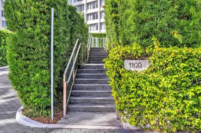 a stairway in a hedge with a sign on it at 1100 West South Beach Lux Waterfront Studio in Miami Beach