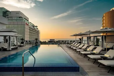a pool on the roof of a hotel with lounge chairs at AC Hotel by Marriott Miami Beach in Miami Beach