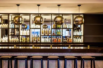 a bar with a lot of bottles of alcohol at AC Hotel by Marriott Miami Beach in Miami Beach