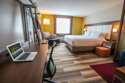 a hotel room with a bed and a laptop on a desk at Holiday Inn Express & Suites Miami Airport East by IHG in Miami