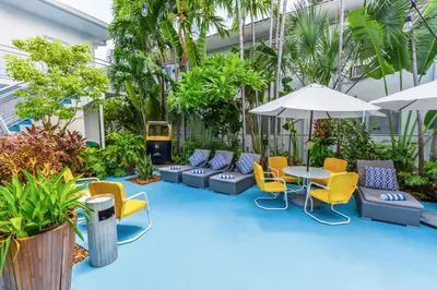 a courtyard with chairs and a table and an umbrella at Seaside All Suites Hotel in Miami Beach