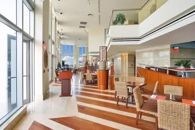 a lobby with tables and chairs in a building at 1BR Apartment with beautiful view in Sunny Isles Beach