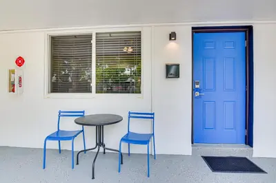 a table and two chairs and a blue door at Centrally Located Hallandale Beach Condo in Hallandale Beach