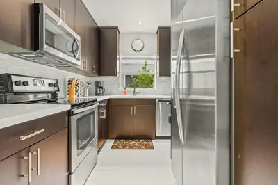 a kitchen with a stainless steel refrigerator at ArtHaus- Fully Stocked Kitchen and Fenced Yard in Miami