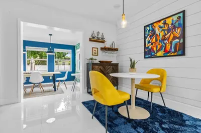 a dining room with yellow chairs and a table at ArtHaus- Fully Stocked Kitchen and Fenced Yard in Miami