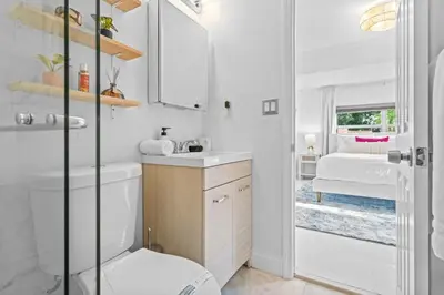 a white bathroom with a sink and a toilet at ArtHaus- Fully Stocked Kitchen and Fenced Yard in Miami