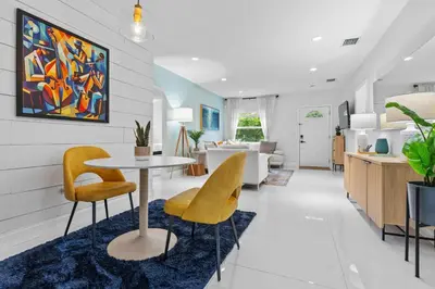 a dining room and living room with a table and chairs at ArtHaus- Fully Stocked Kitchen and Fenced Yard in Miami