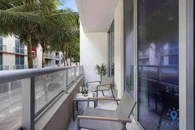 a balcony with two chairs and a table on a building at 2BR Apartment with Rooftop Pool in Hollywood