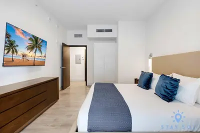 a bedroom with a large bed with blue pillows at 2BR Apartment with Rooftop Pool in Hollywood