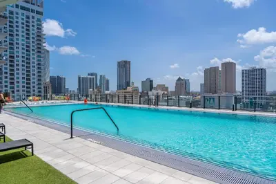 a large swimming pool with a city skyline in the background at Luxury Downtown Miami Apartment in Miami