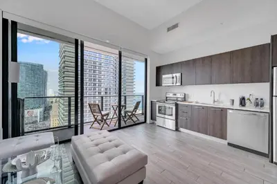 a kitchen with a living room with a large window at Luxury Downtown Miami Apartment in Miami