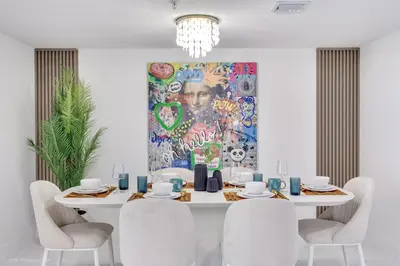 a dining room with a white table with chairs and a painting at Lux 3BR City-View Retreat in Hollywood, 5th Floor in Hollywood