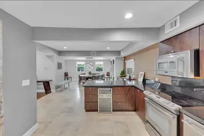 a large kitchen with stainless steel appliances and a living room at Ft Lauderdale Casa de Las Olas in Fort Lauderdale