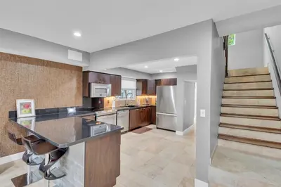 a large kitchen with a counter and a staircase at Ft Lauderdale Casa de Las Olas in Fort Lauderdale