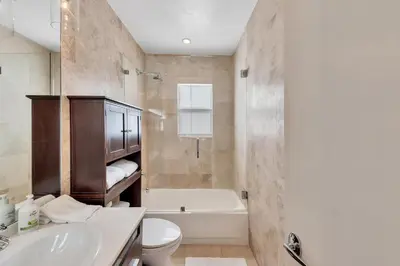 a bathroom with a tub and a toilet and a sink at Ft Lauderdale Casa de Las Olas in Fort Lauderdale