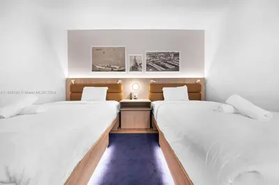 two beds in a room with white walls at 2 bedroom Condo at Gale Downtown Pool Gym SPA in Miami